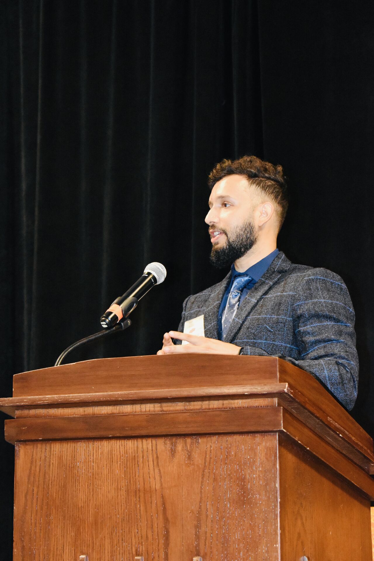 Dr. Kushal Jha presenting at a podium